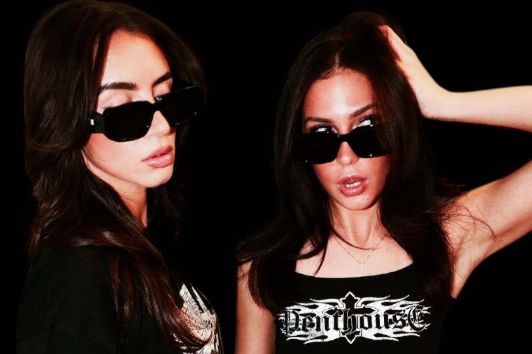 Two women wearing black crop tops with visible branding against a dark background